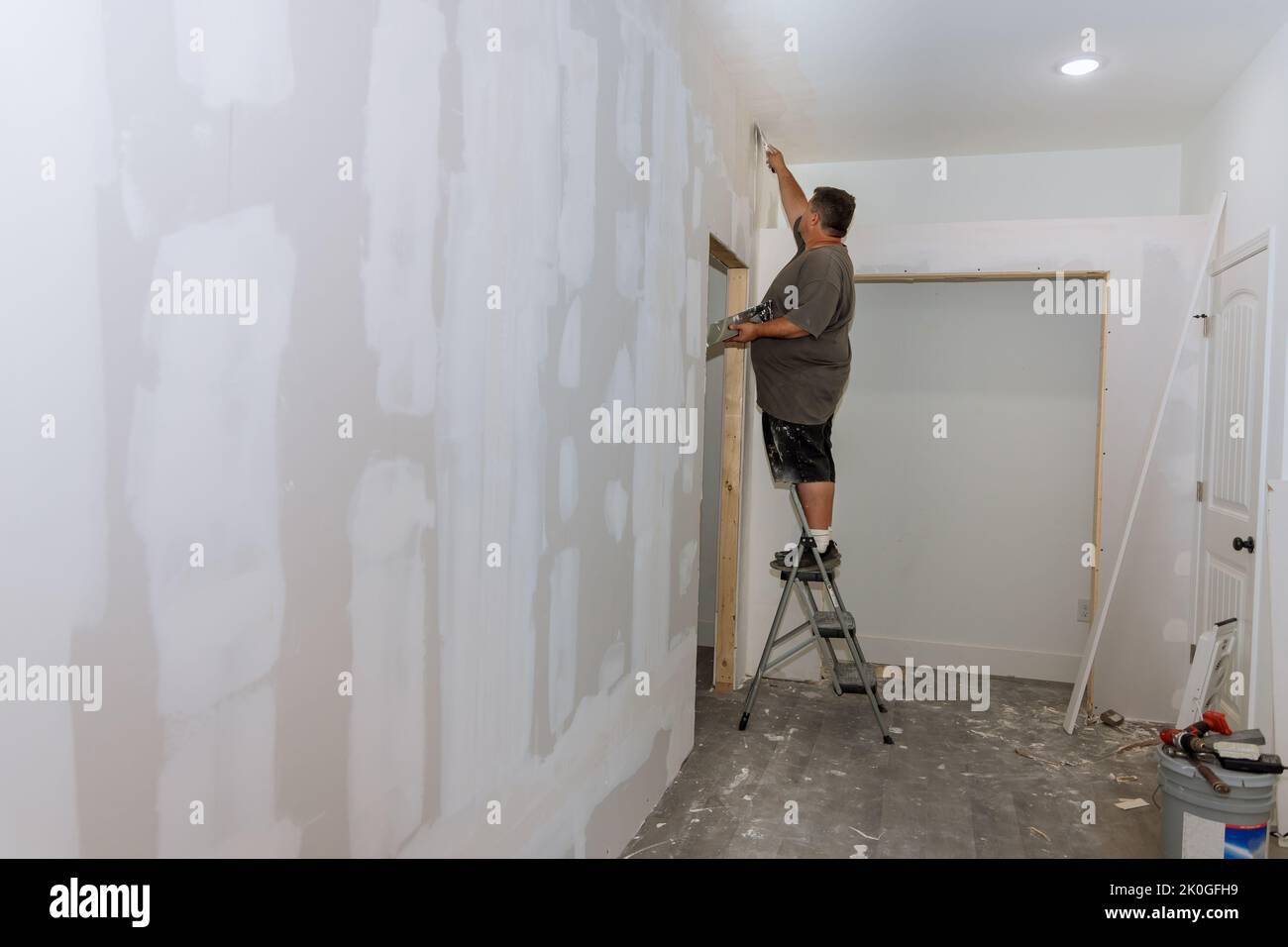 The worker trowels putty on drywall finishing putty with a spatula the