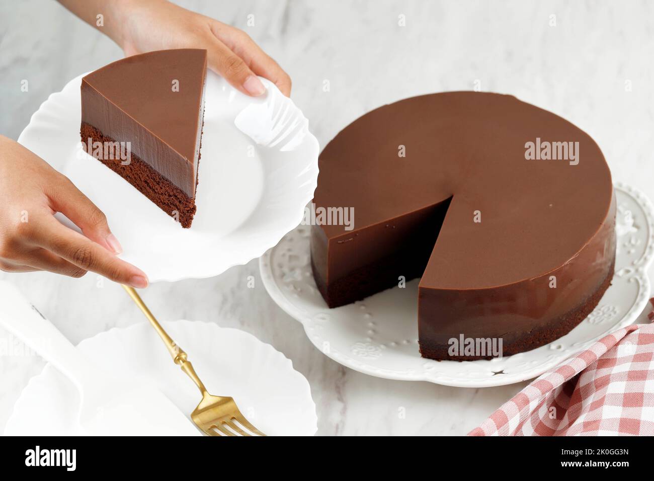 Women Hand Served Slice of Homemade Dessert Puding Cokelat or Chocolate Pudding on White Plate Stock Photo