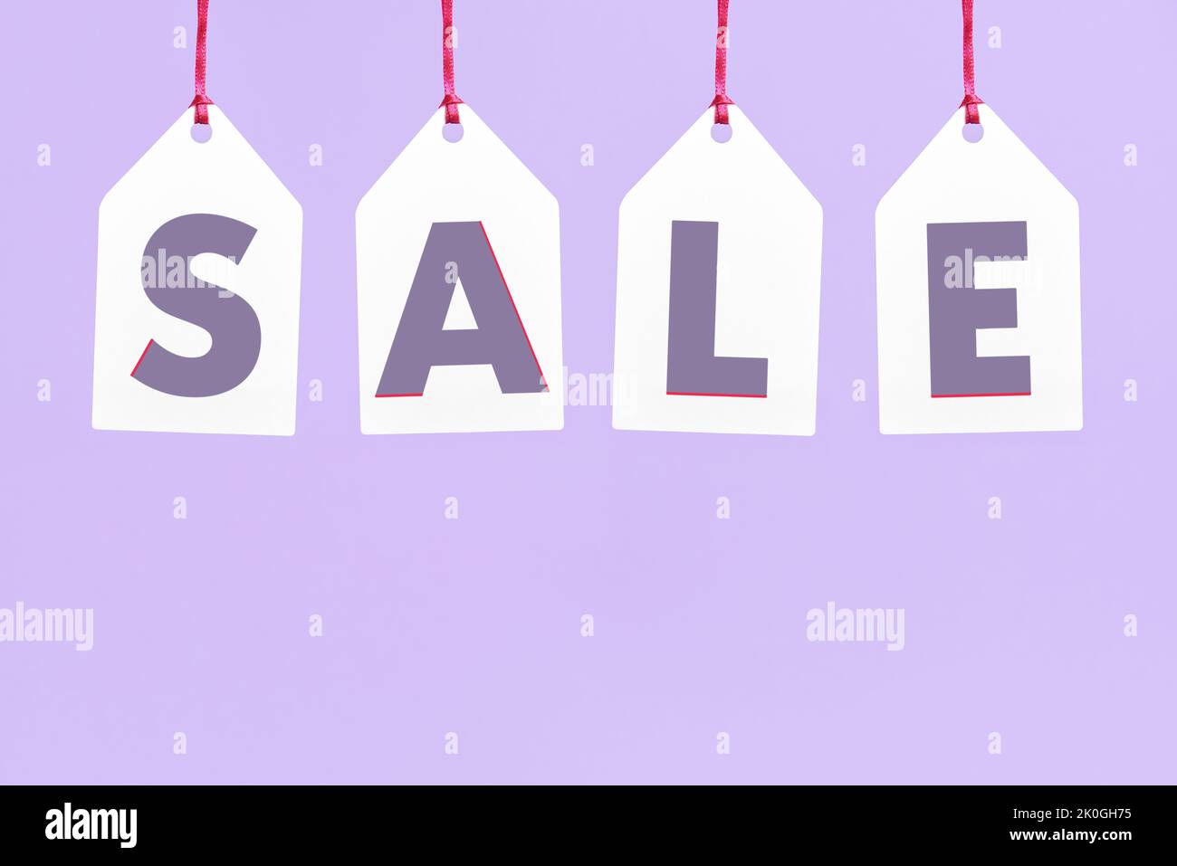 Word Sale written on white paper labels hanging on a pastel lilac background. Simple design with copy space. Concepts: seasonal sales and discounts, b Stock Photo