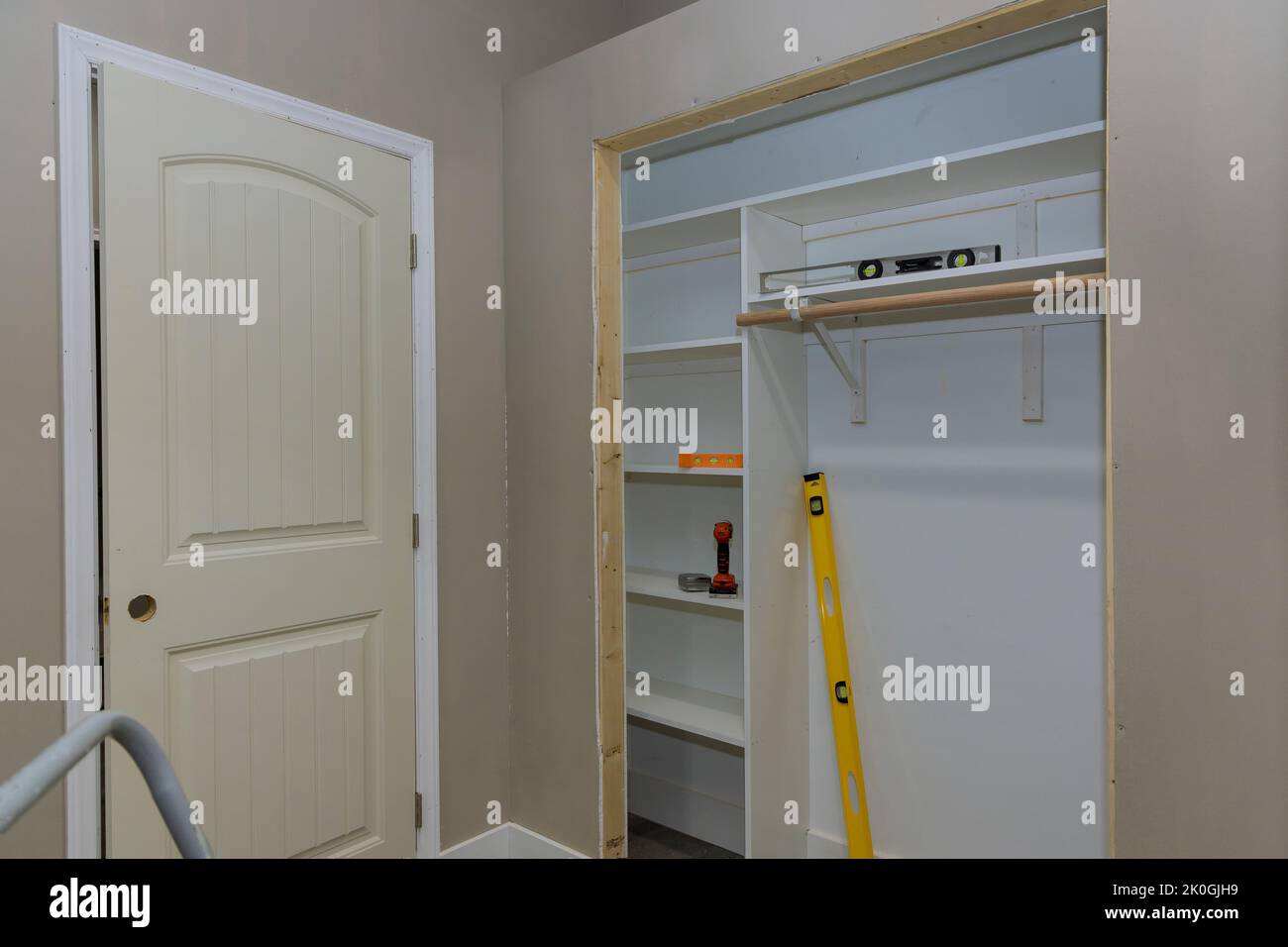 Adding a white melamine shelf to the interior of a clothing closet in