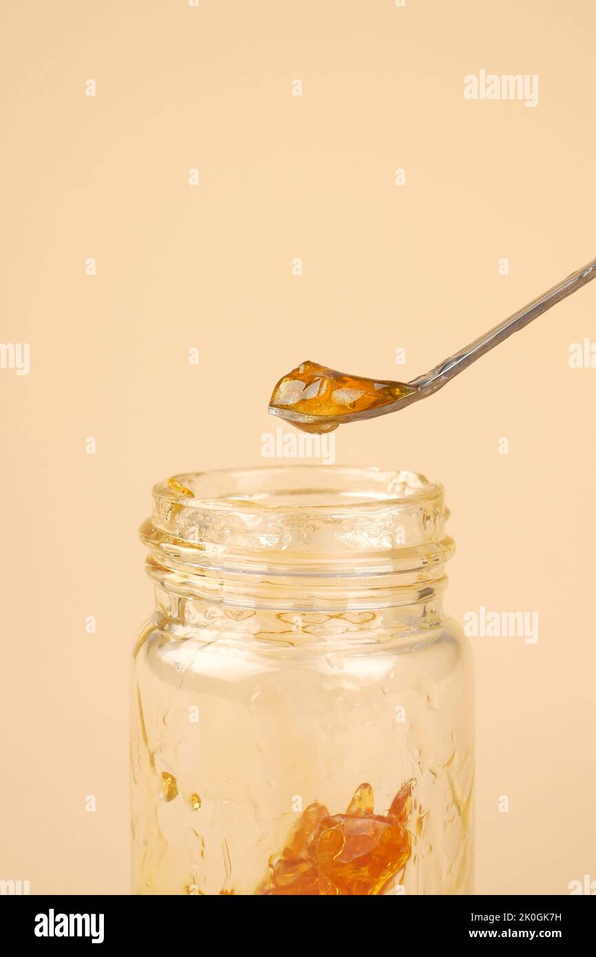jar with pieces of concentrated cannabis wax for smoking, marijuana high thc wax. Stock Photo