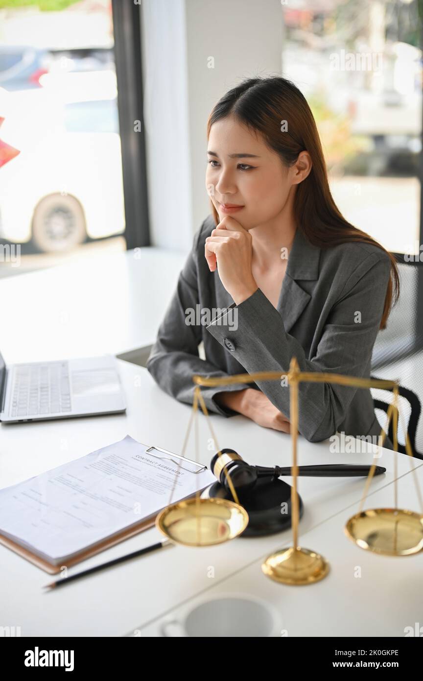 Portrait, Professional and beautiful Asian female lawyer or legal advisor sitting at her office desk. Stock Photo