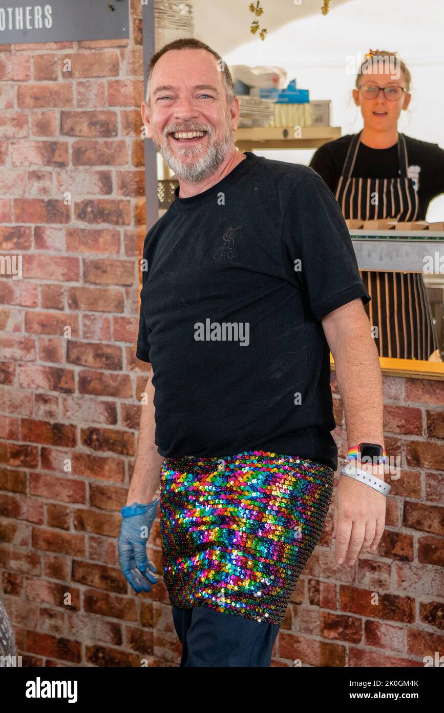 Adam Woodyatt (Eastenders 'Ian Beal') seen smiling in sequin mini skirt helping to serve food at the festival, Pub in The Park, now the biggest food and music festival to tour the UK made a stop at St Albans in Hertfordshire Saturday afternoon the live music stage featured music artists Kaiser Chiefs - Ricky Wilson, Andrew White, Simon Rix, Vijay Mistry and Nick 'peanut' Baines, Melanie C/ Mel C who is best known as one of the five members of the Spice Girls, during which time she was nicknamed Sporty Spice and the band Dodgy. Also spotted around the festival site were 'Hairy Biker'- Si King Stock Photo