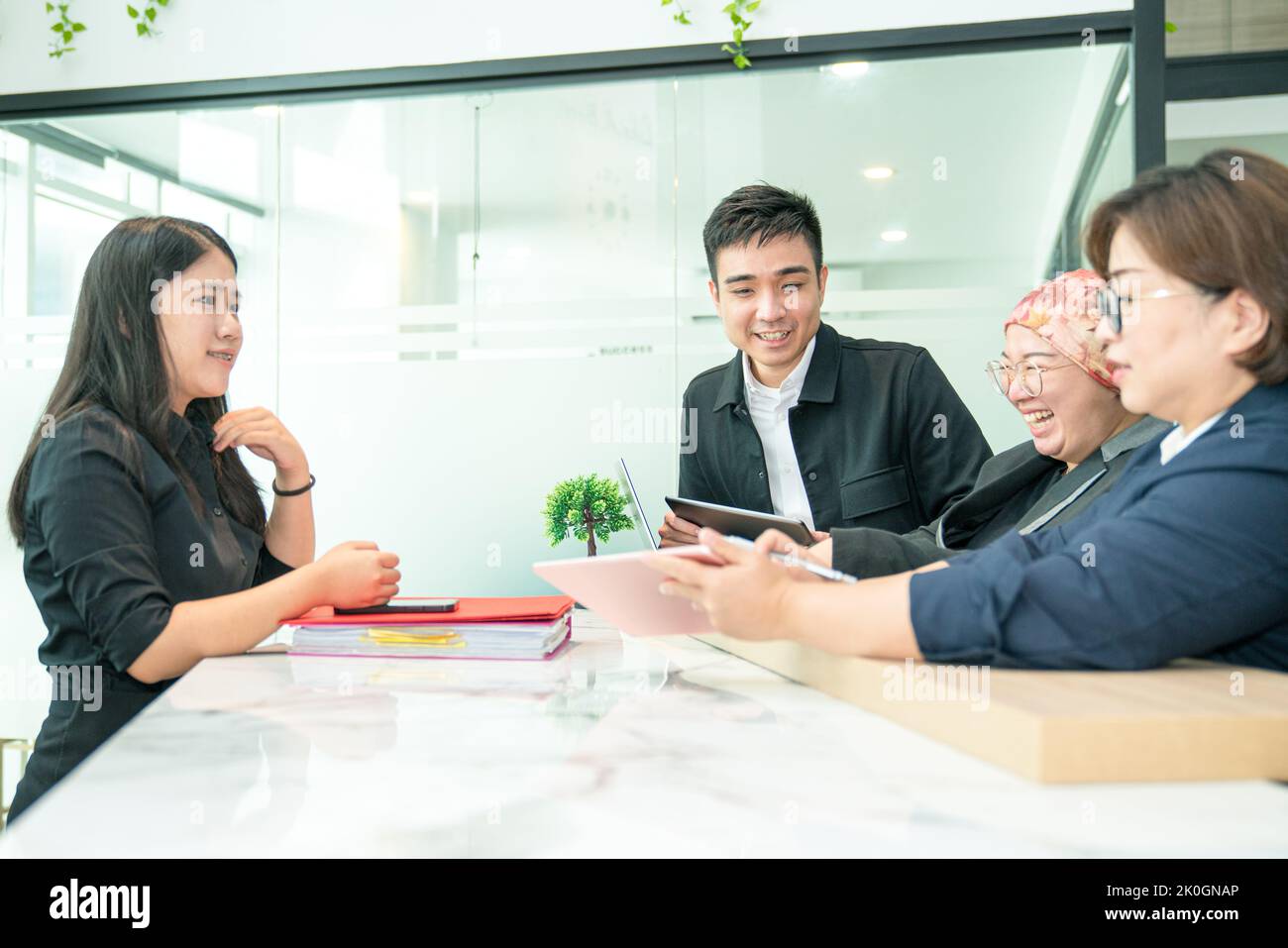 Friendly colleagues work team working together, laughing with positive emotions in the office. Stock Photo
