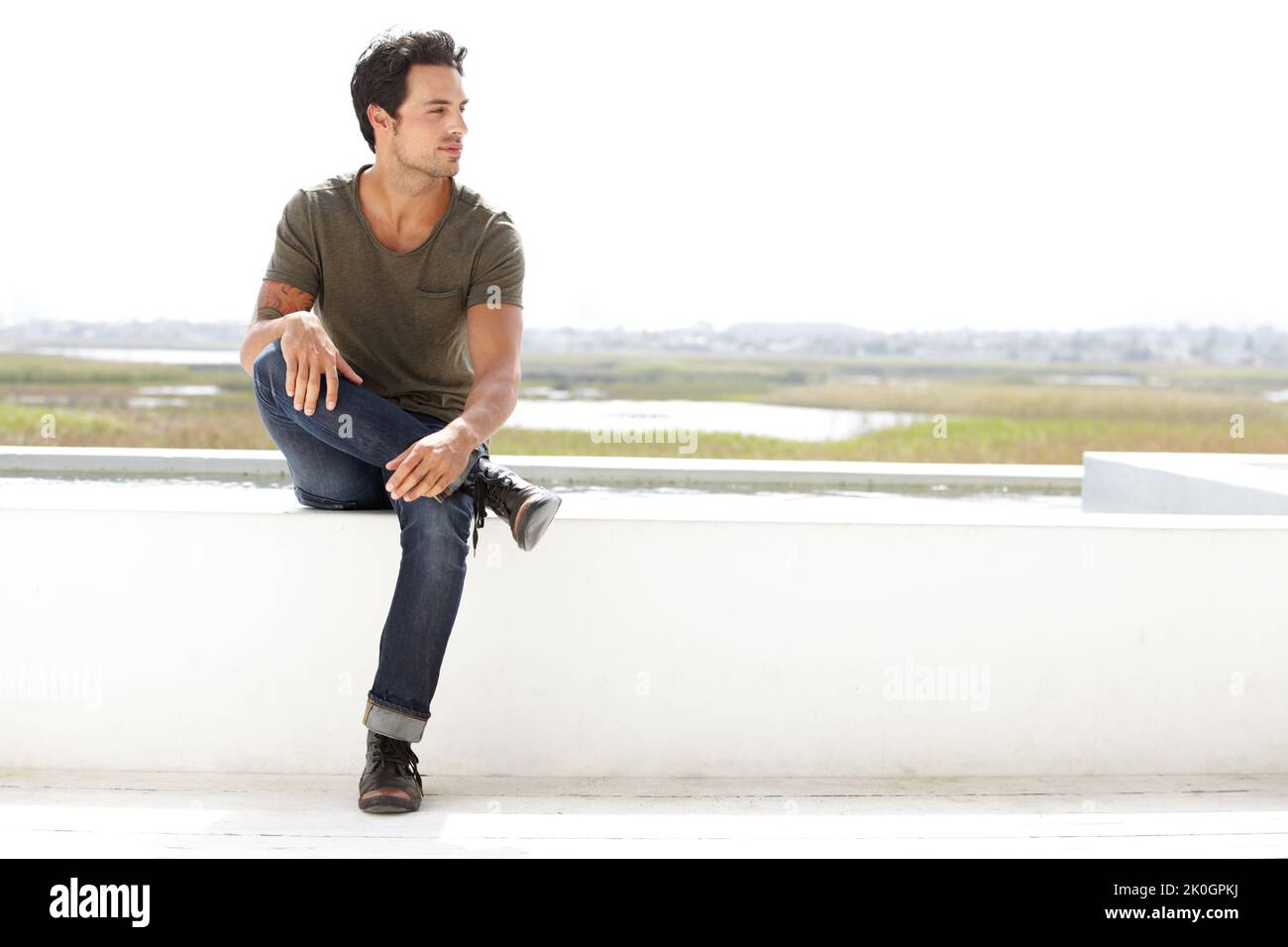 Feeling relaxed. A handsome young man looking thoughtful while sitting outside. Stock Photo