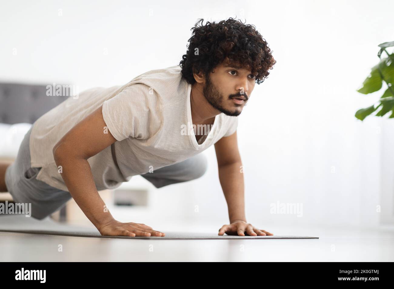 Motivated hindu guy doing workout at home, copy space Stock Photo