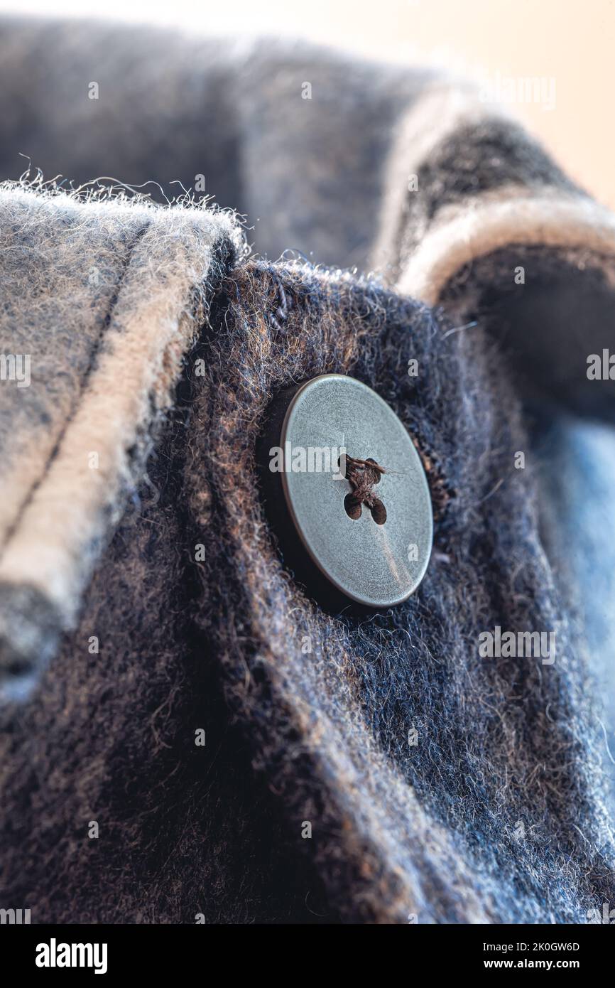 Button on a warm blue shirt, macro shot. Stock Photo