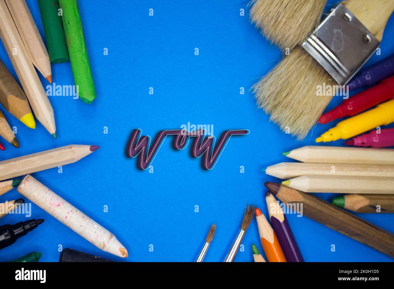 Overhead shot of school supplies with Wow text. Brushes, pencils, artistic tools. Art And Craft Work Tools. Stock Photo