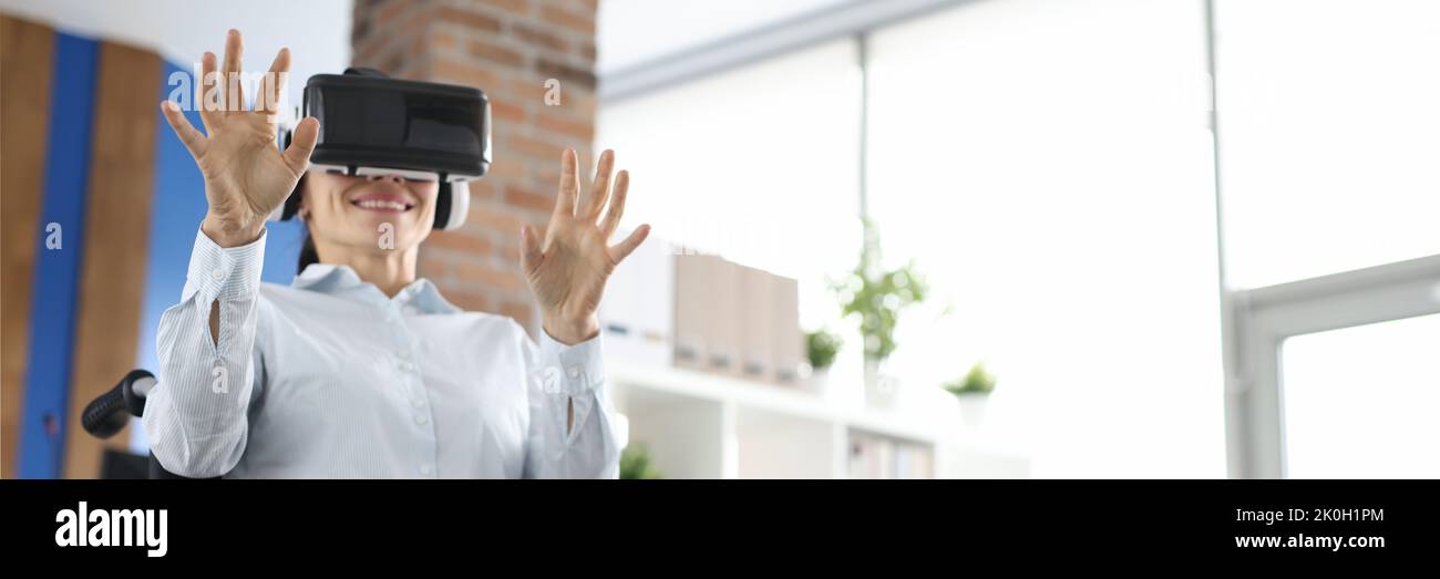 Woman in wheelchair wearing virtual glasses in room Stock Photo - Alamy