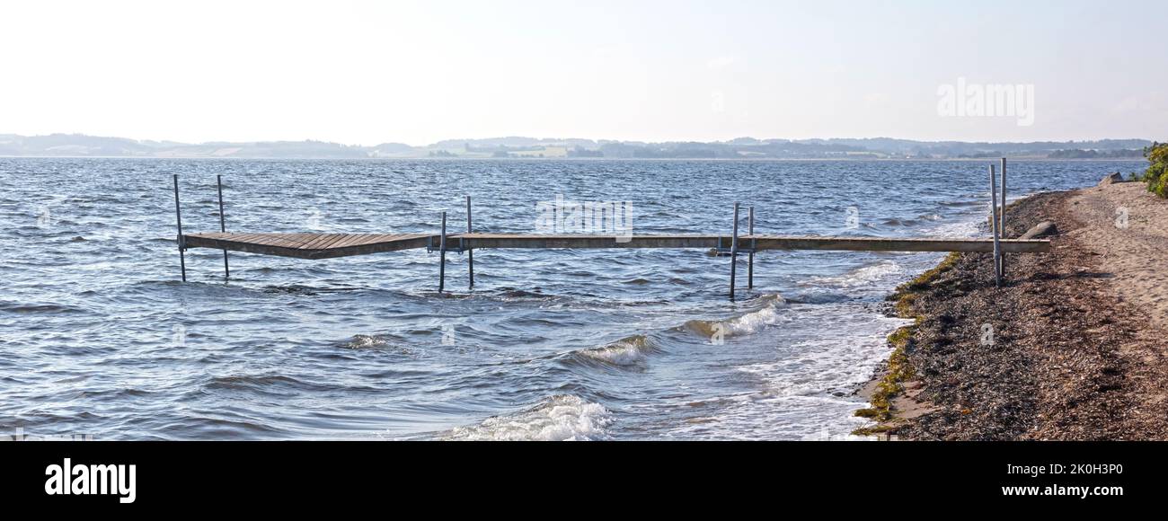 Seascape tranquil background with room for text, broken jetty in the middle Stock Photo