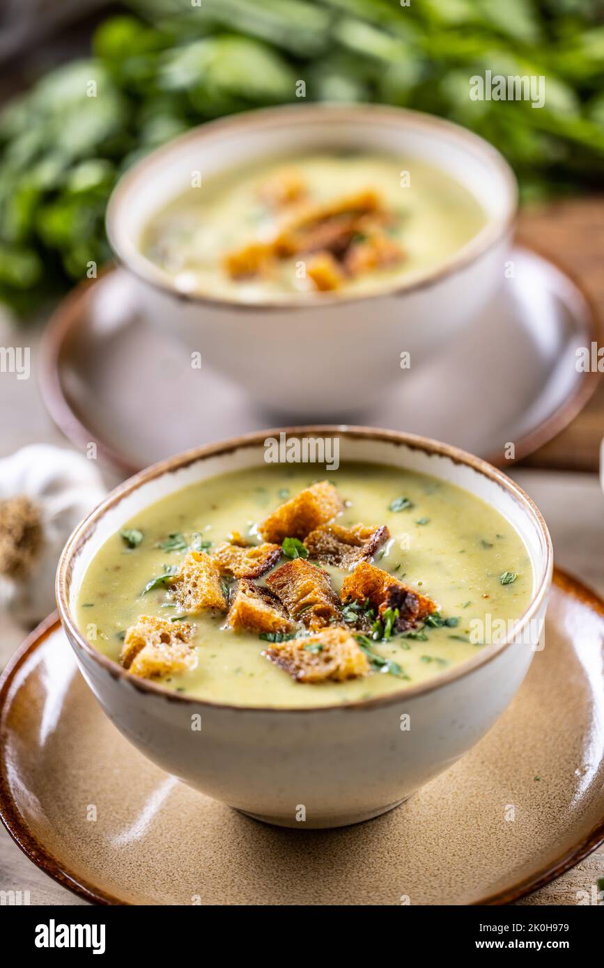 Garlic cream soup with bread croutons and flavored with copped celery leaves. Stock Photo
