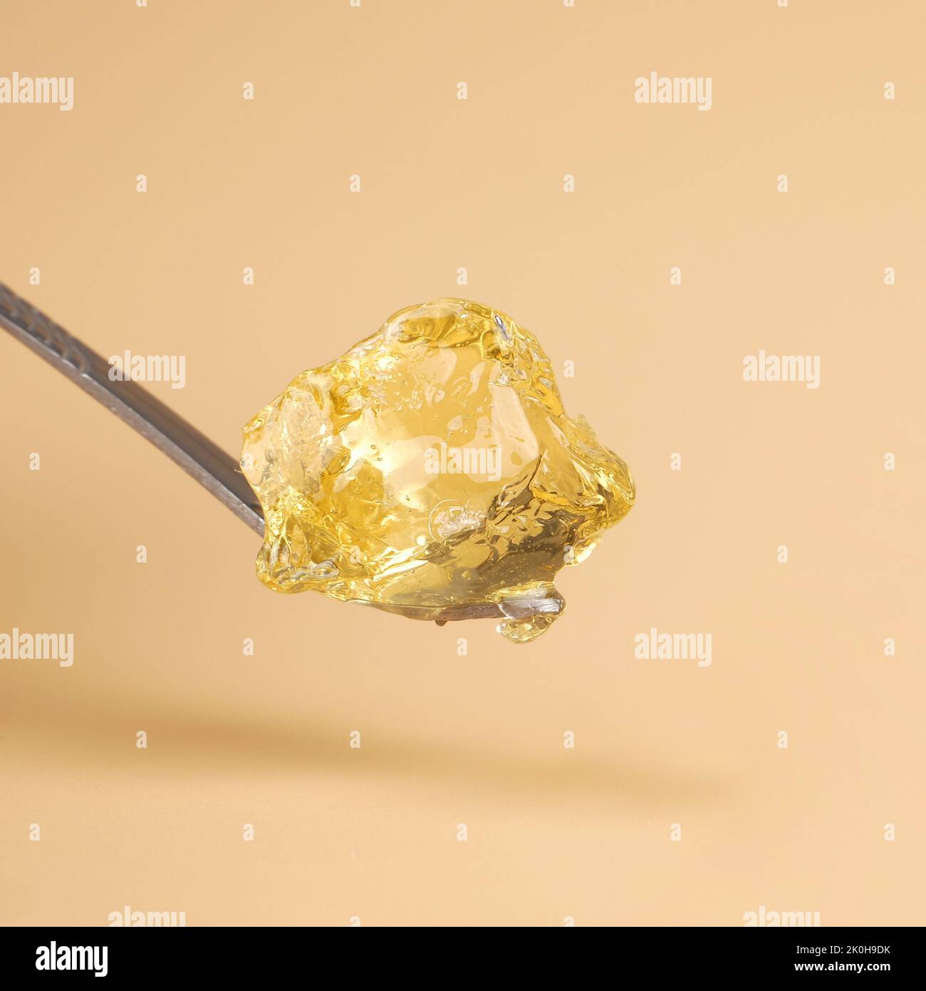 a piece of concentrated cannabis wax , high thc golden dab. Stock Photo