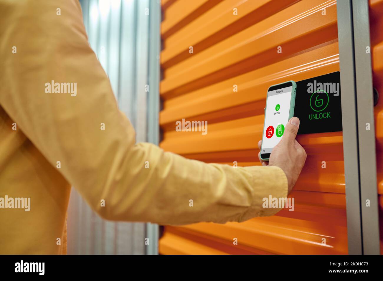 Worker opening the storage unit door with the smartphone Stock Photo
