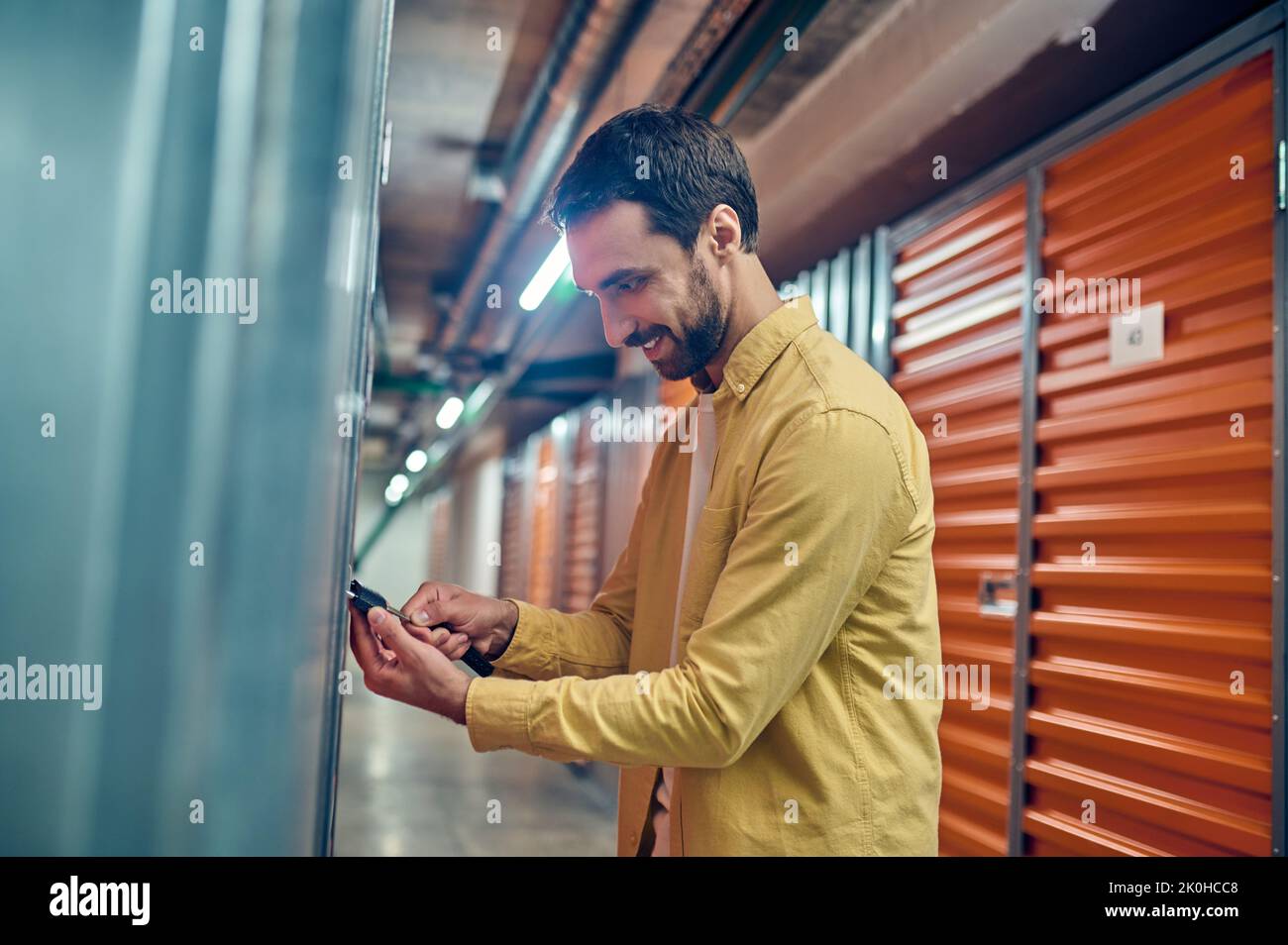 Man concentrated on padlocking the storage unit door Stock Photo Alamy