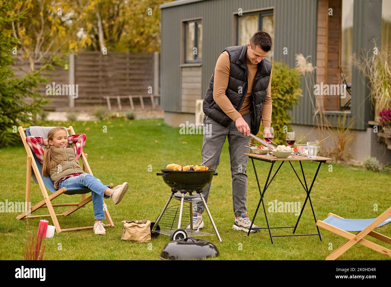 Cheerful daughter and her dad having the barbecue party Stock Photo