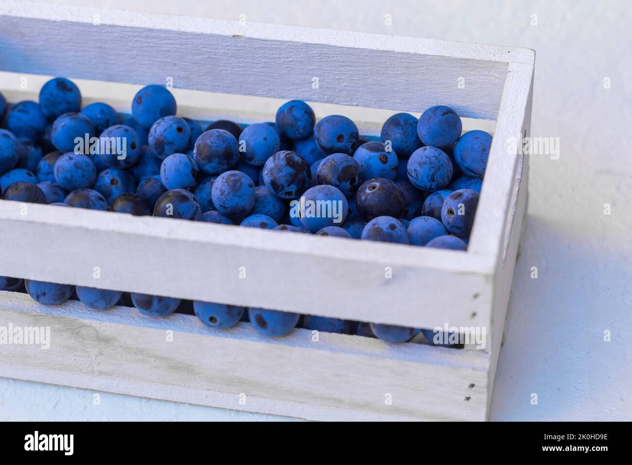 Sloe berries in wooden chest Stock Photo