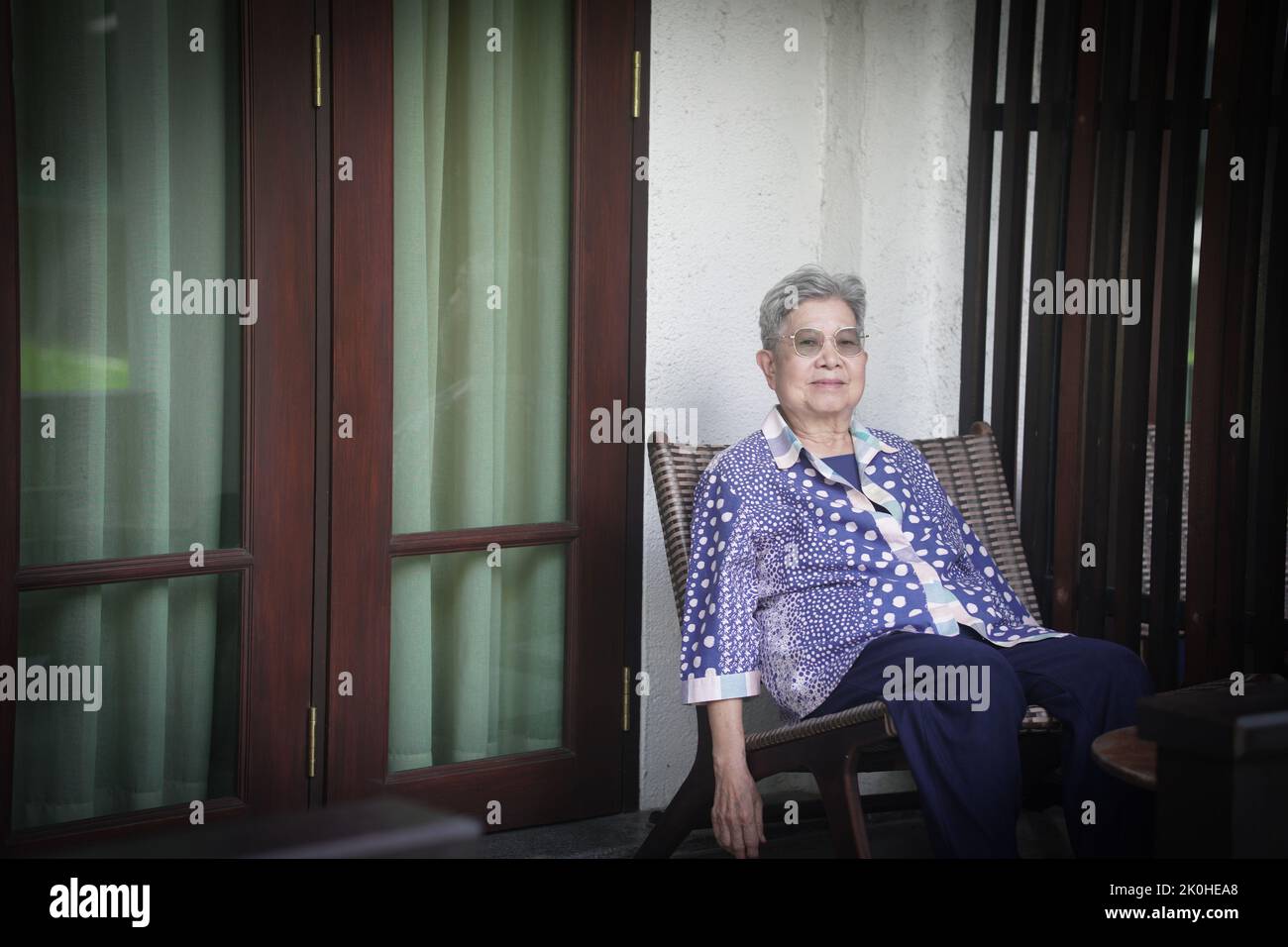 old elderly elder senior woman resting relaxing on terrace balcony Stock Photo