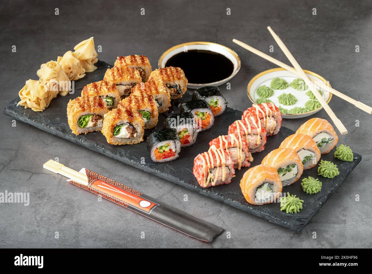 Sushi set of various products on a black stone plate. Blur background and selective focus Stock Photo