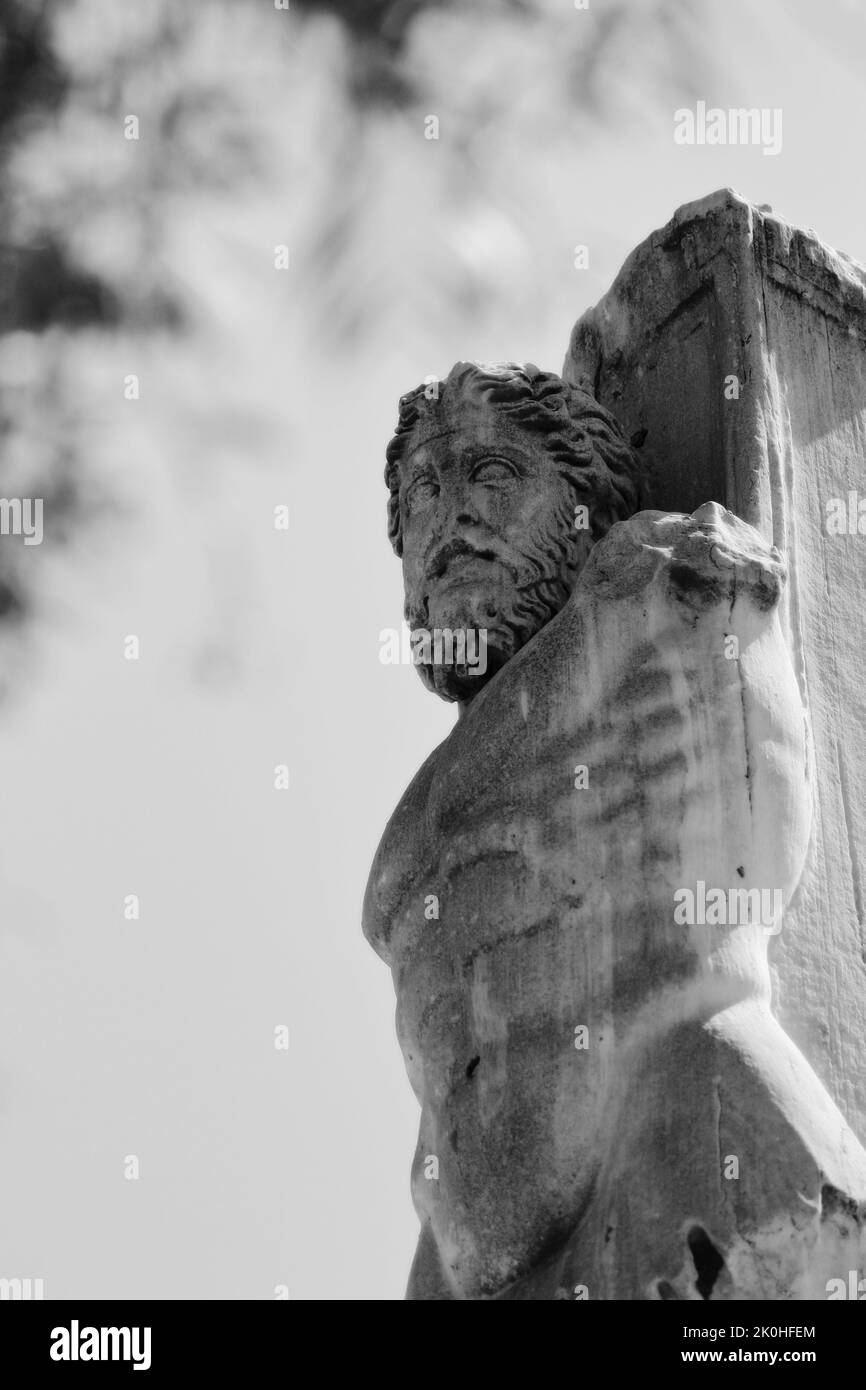 A vertical grayscale shot of a statue in the Palace of the Giants