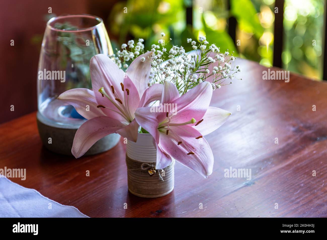 Beautiful pink Madonna lily flower in a pot on a dining table Stock