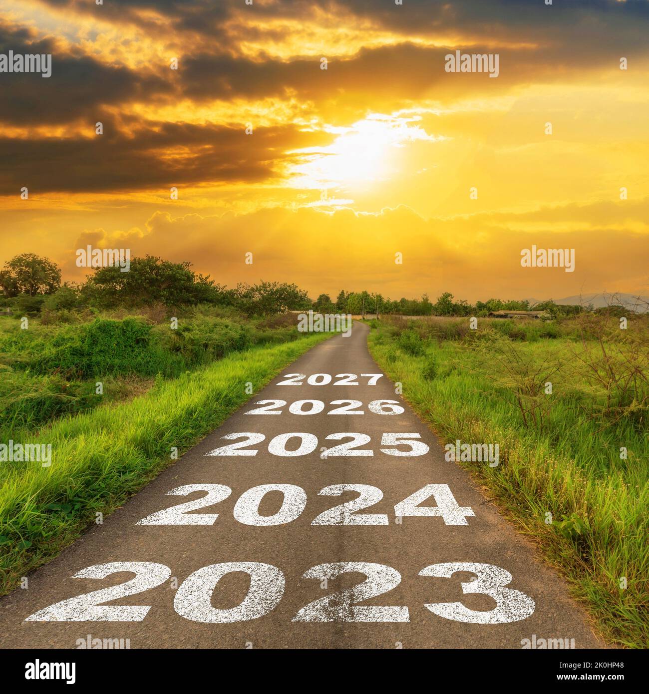 Empty asphalt road and New year 2023 concept. Driving on an empty road to 2023 with sunset. Stock Photo
