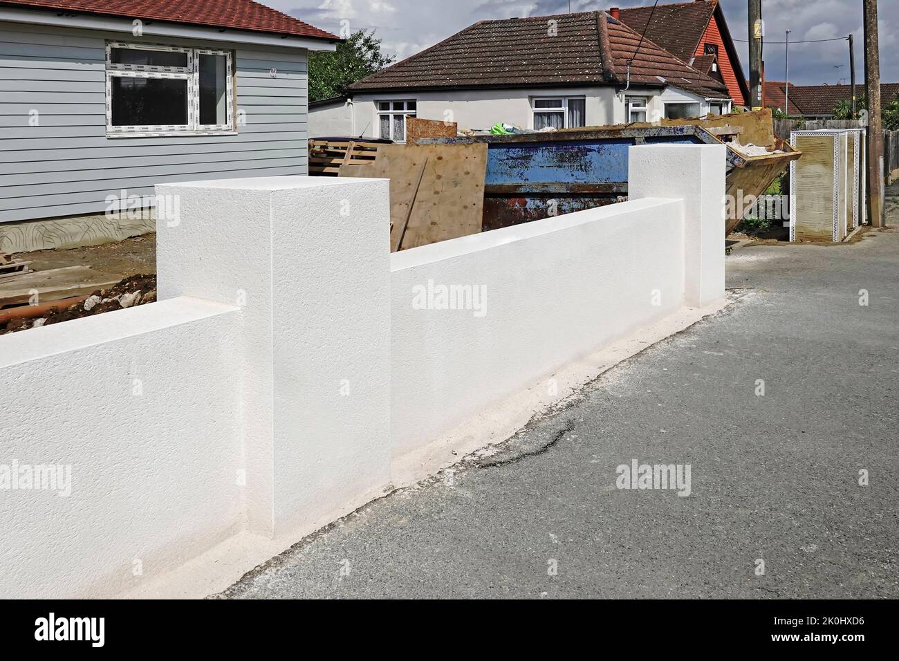Monocouche through colour render finish on part of front concrete boundary wall also using white plastic non rust arris beads to new build bungalow UK Stock Photo