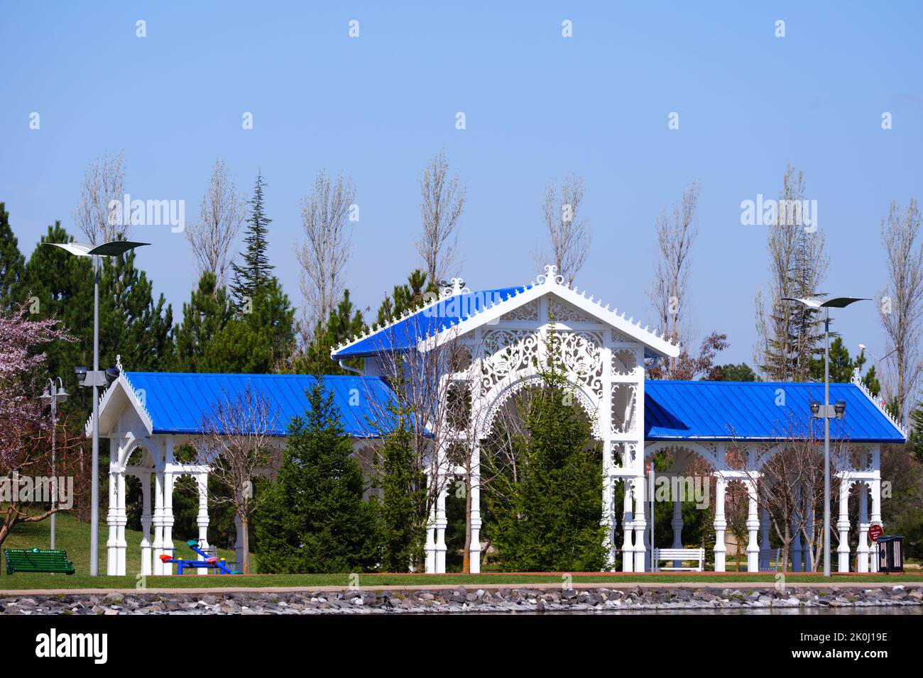 Nostalgic wooden train station with blue roof within trees lakeside in summer Stock Photo