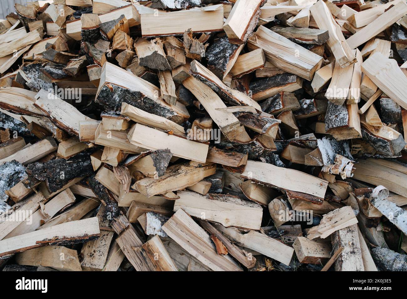 Birch firewood pile texture, split with axe pieces piled in a big heap. High and wide. Stock Photo