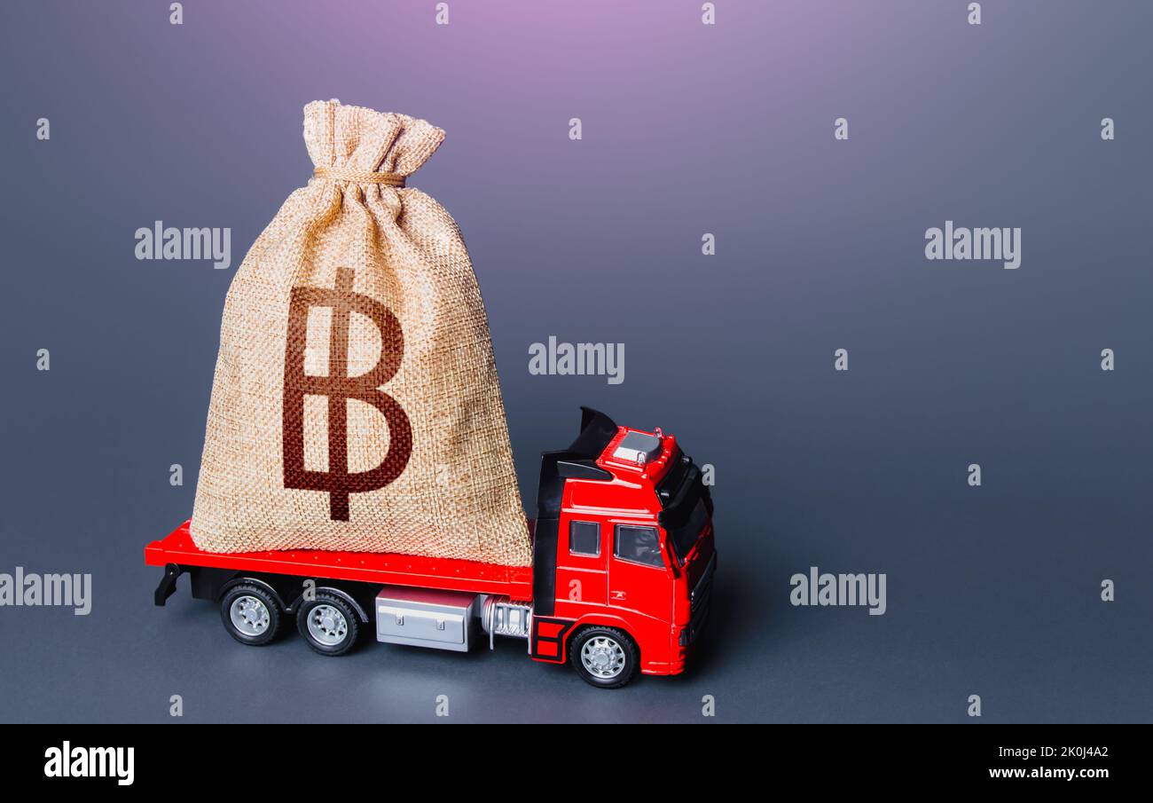 Truck with a thai baht money bag. High super income. Loan or deposit. Financial aid, investments and subsidies. Compensation. Payment of taxes. Debt. Stock Photo