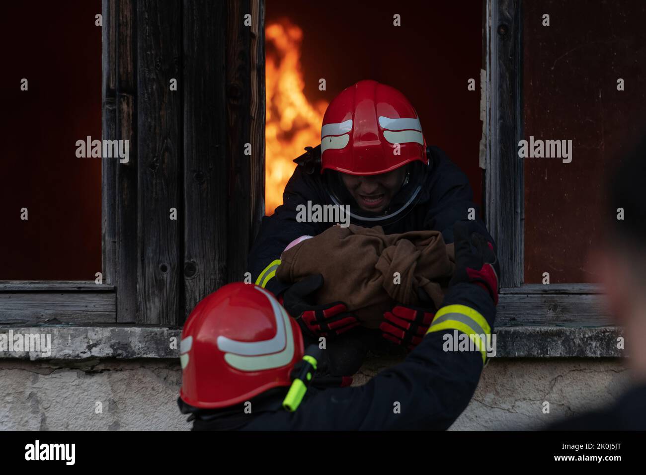 Firefighter hero carrying baby girl out from burning building area from ...
