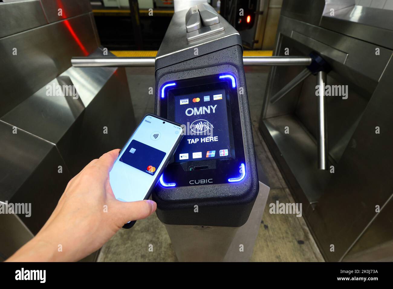 An NFC smartphone with Google Wallet taps a NYC subway turnstile
