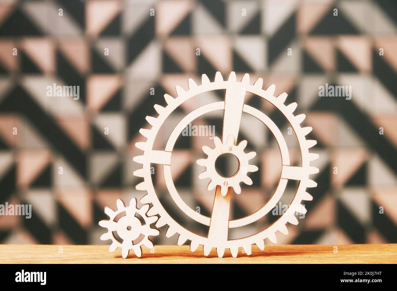 Big and small wooden gear wheels connected on the table. Puzzle games