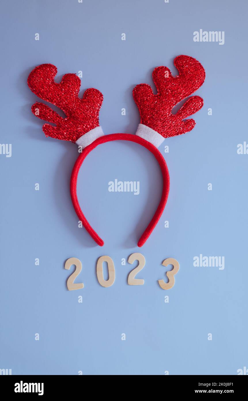 Top view of numbers 2023. Red cartoon deer horns close up. Blue background. New year, Christmas  celebration. Stock Photo