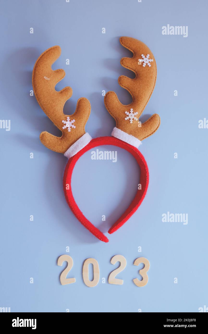 Top view of numbers 2023. Red cartoon deer horns close up. Blue background. New year, Christmas  celebration. Stock Photo