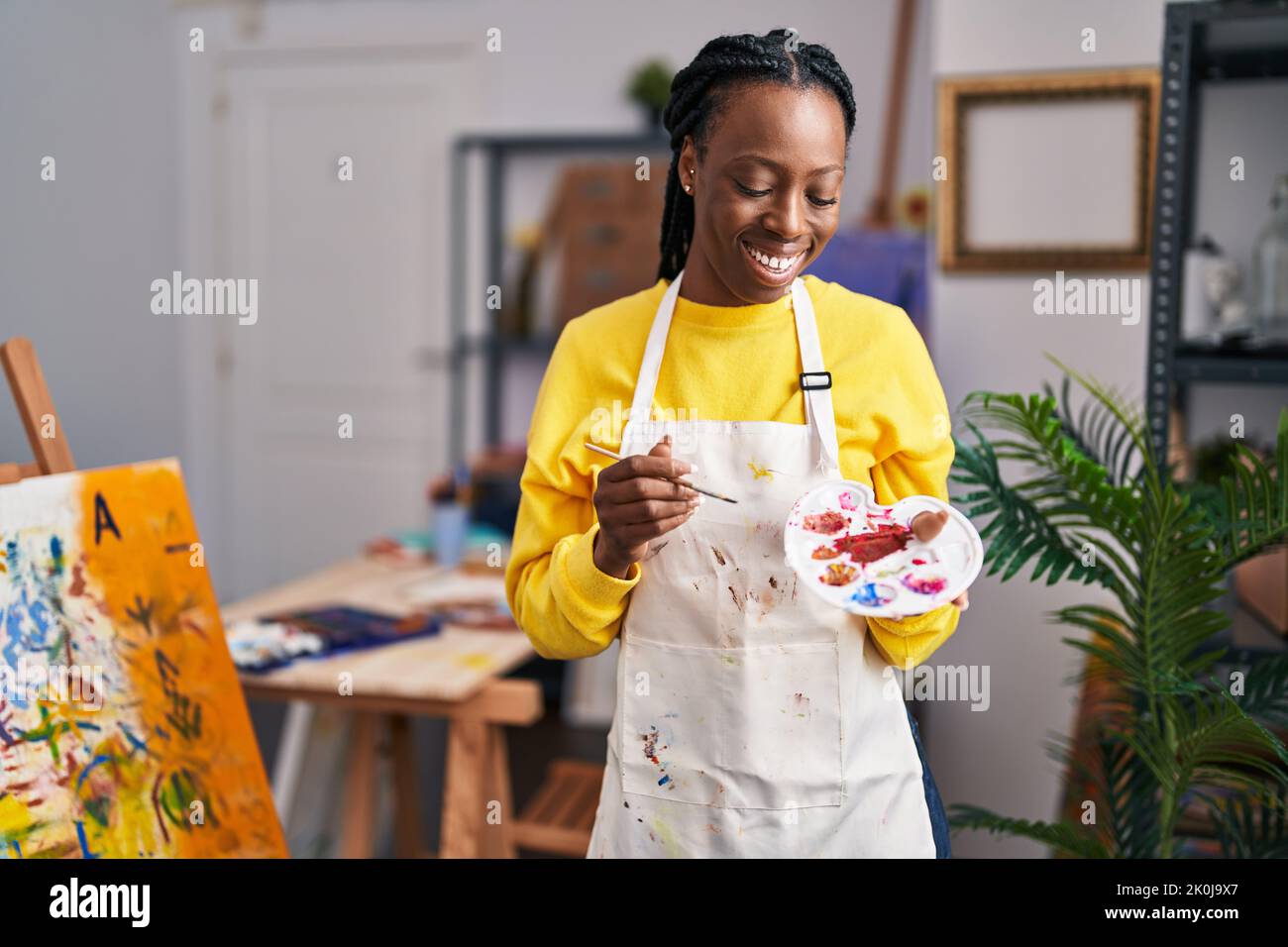 African american woman artist smiling confident holding paintbrush and ...