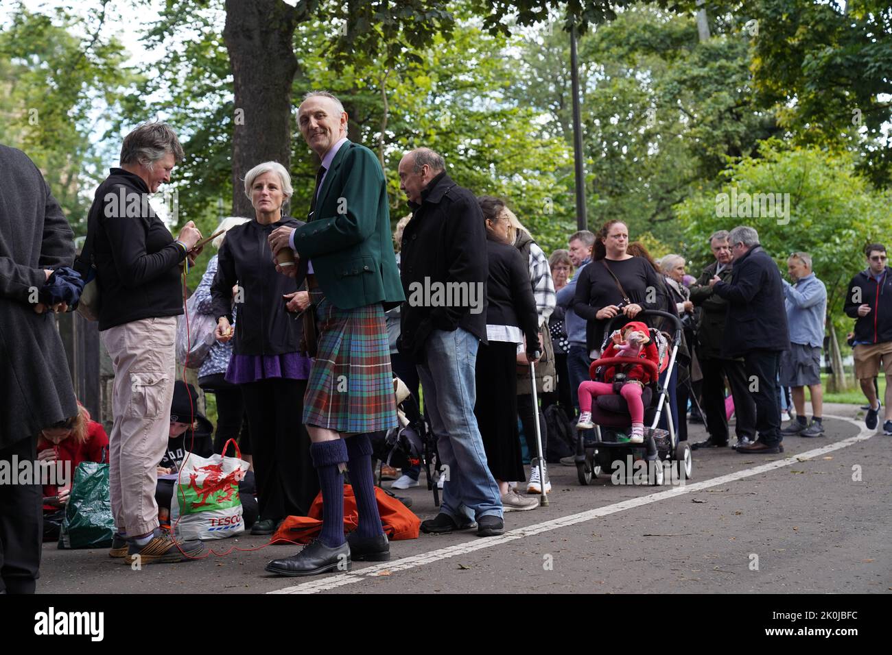 People queue at the Meadows in Edinburgh to obtain a wrist band