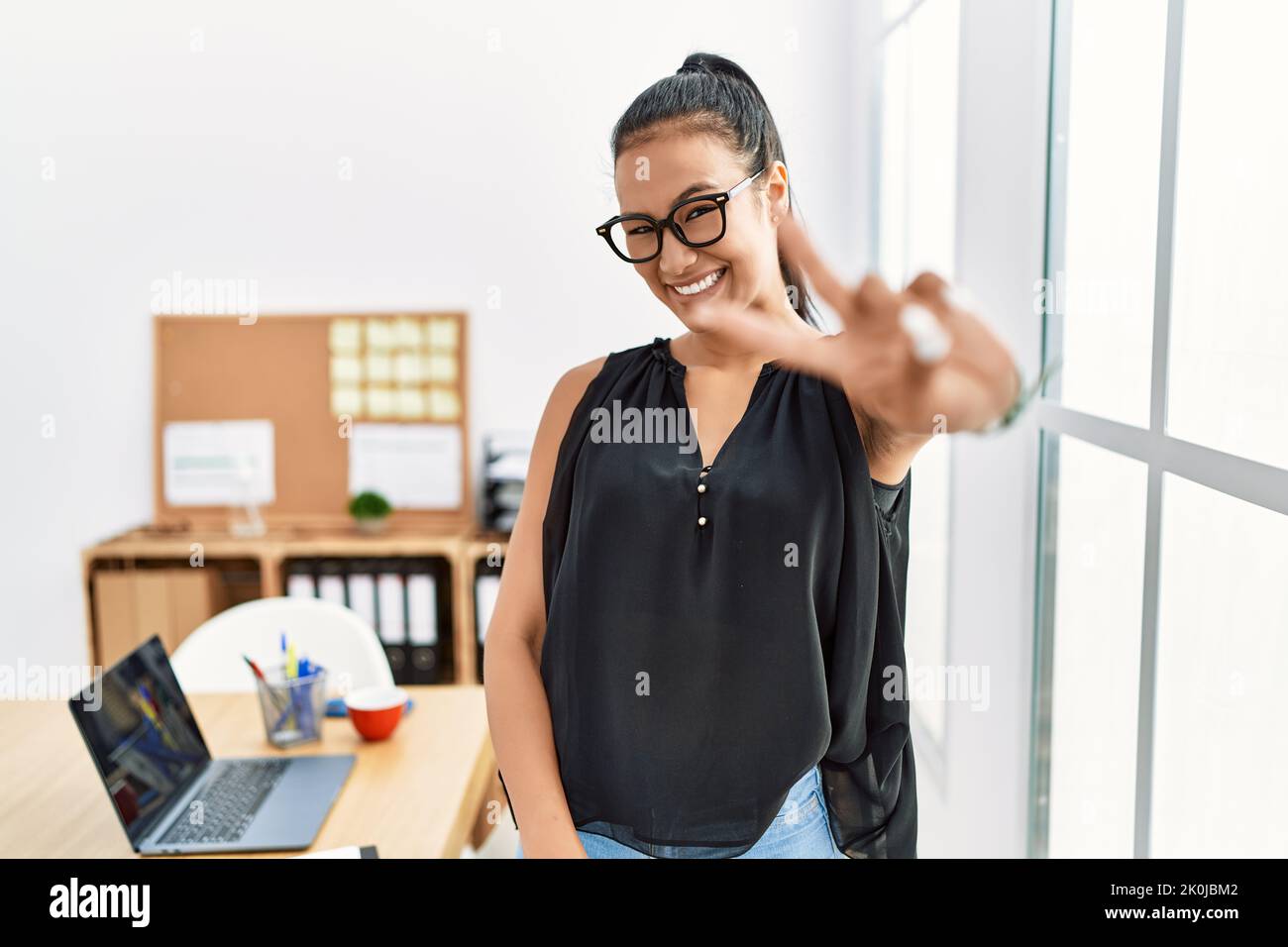 Young hispanic business woman working at the office smiling looking to ...