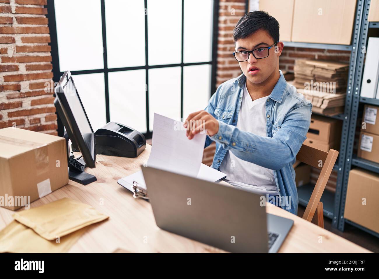 Down syndrome man ecommerce business worker reading document at office Stock Photo