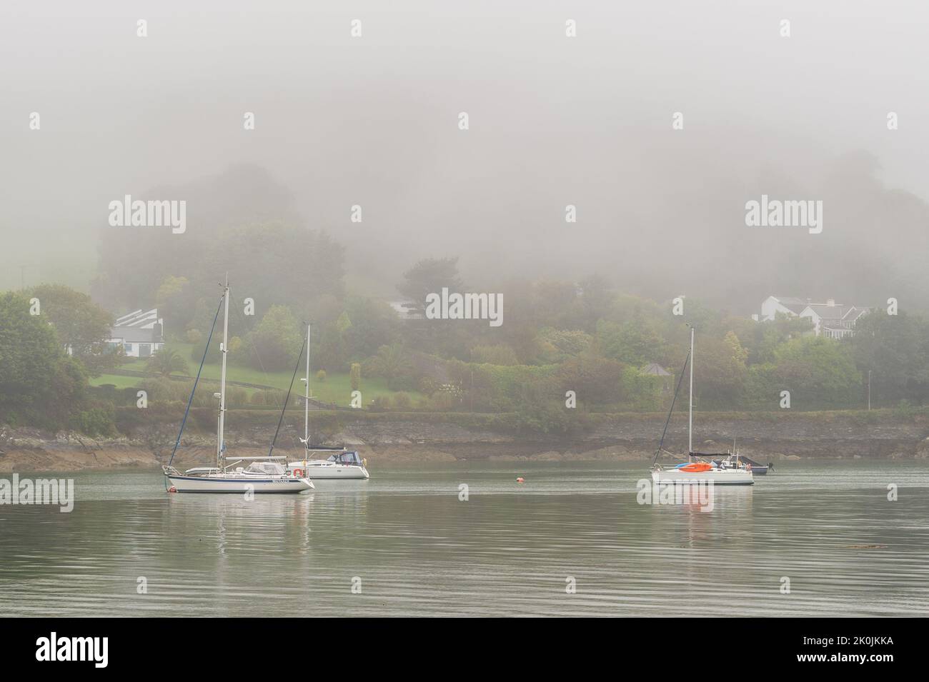 Union Hall, West Cork, Ireland. 12th Sep, 2022. Mist almost envelops boats moored in Union Hall on a dull and wet day in West Cork. Met Éireann has forecast brighter weather over the next few days. Credit: AG News/Alamy Live News Stock Photo