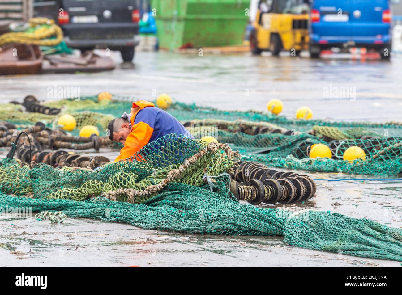 Union Hall, West Cork, Ireland. 12th Sep, 2022. A fisherman mends his nets on Keelbeg Pier in Union Hall on a dull and wet day in West Cork. Met Éireann has forecast brighter weather over the next few days. Credit: AG News/Alamy Live News Stock Photo