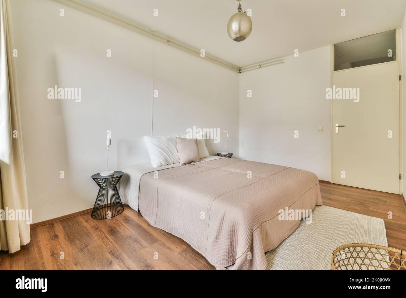 Wide bed in light bedroom Stock Photo - Alamy