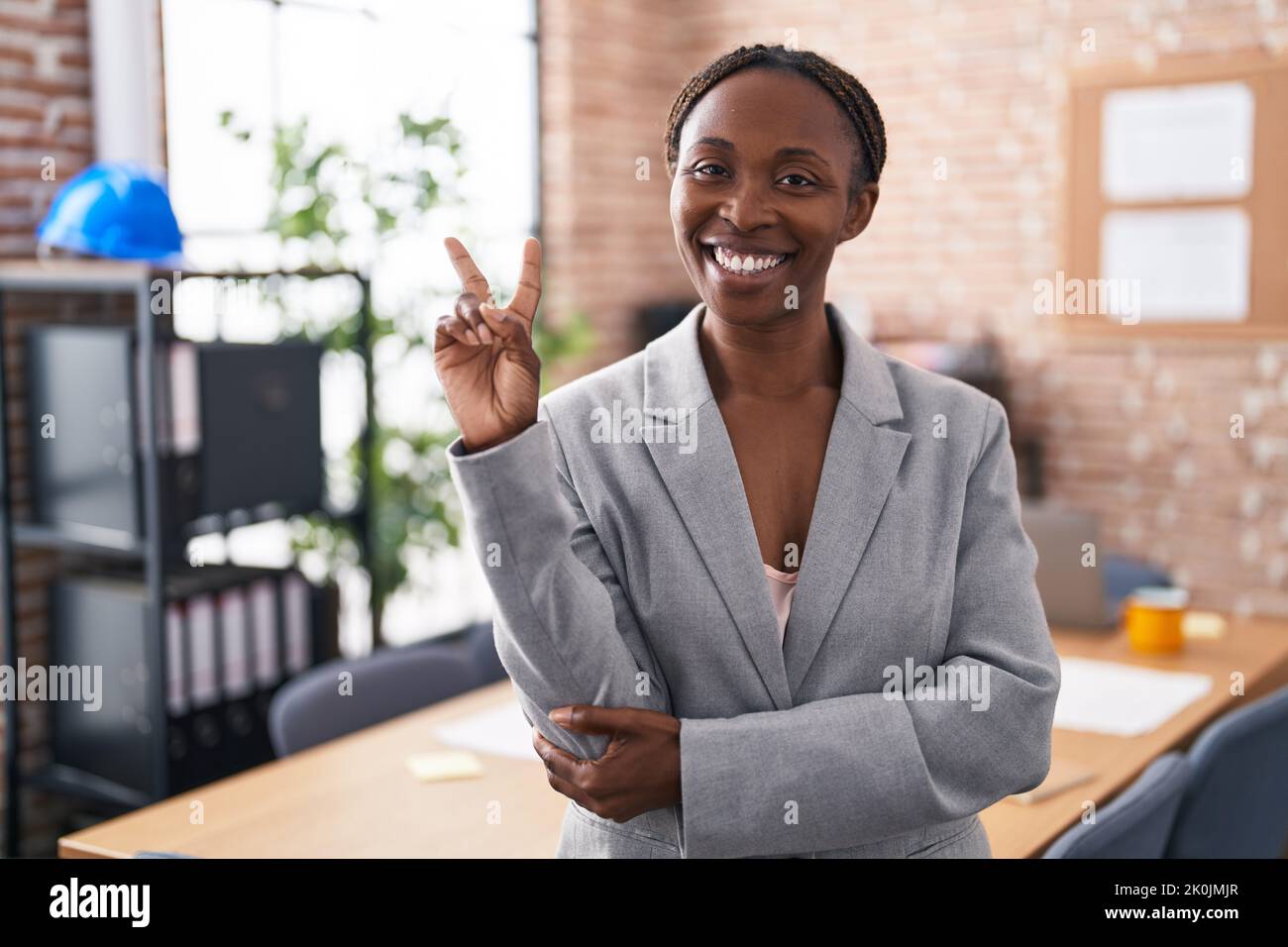 African american woman at the office smiling with happy face winking at ...