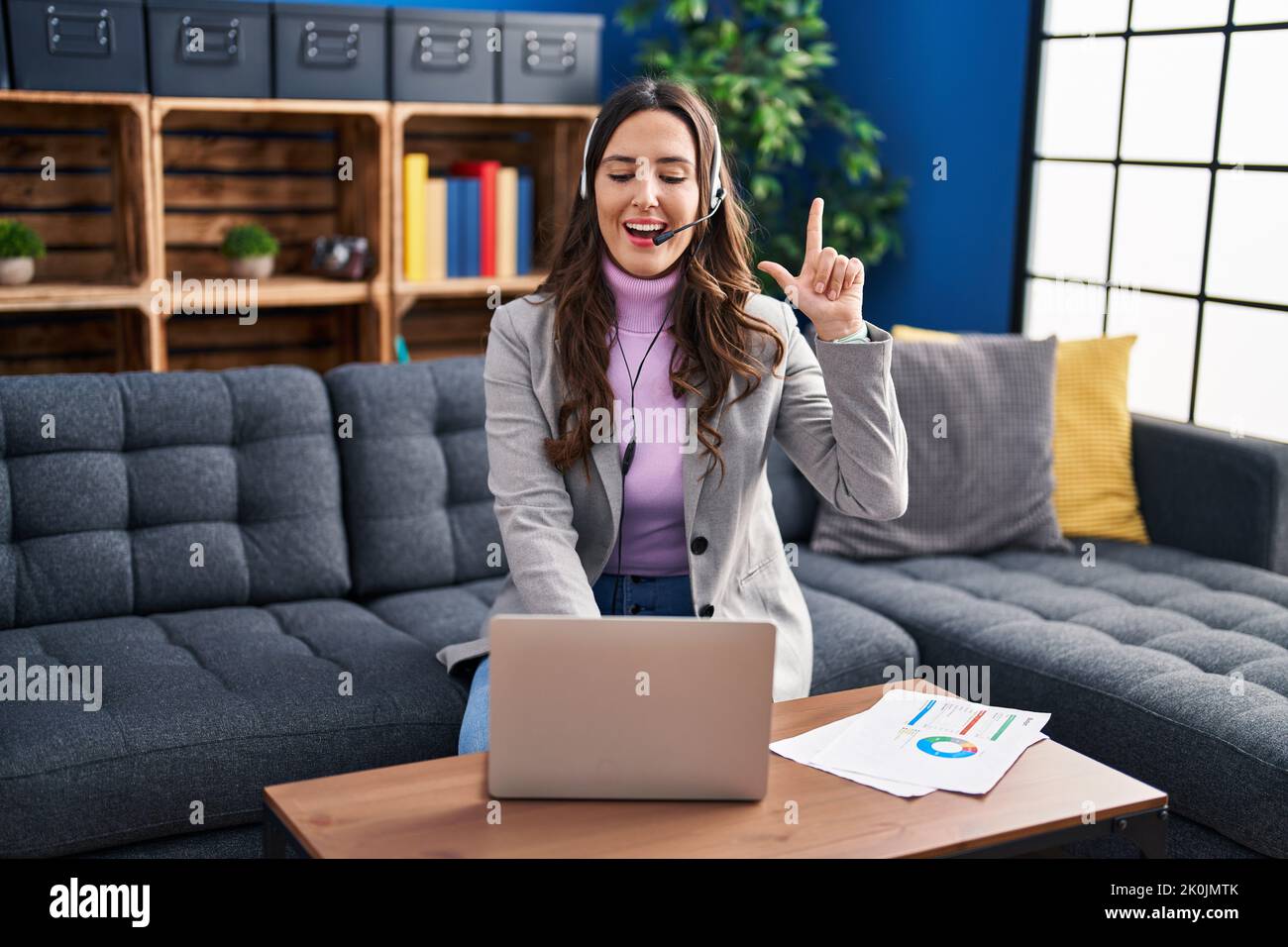 Young brunette woman working using computer laptop surprised with an ...