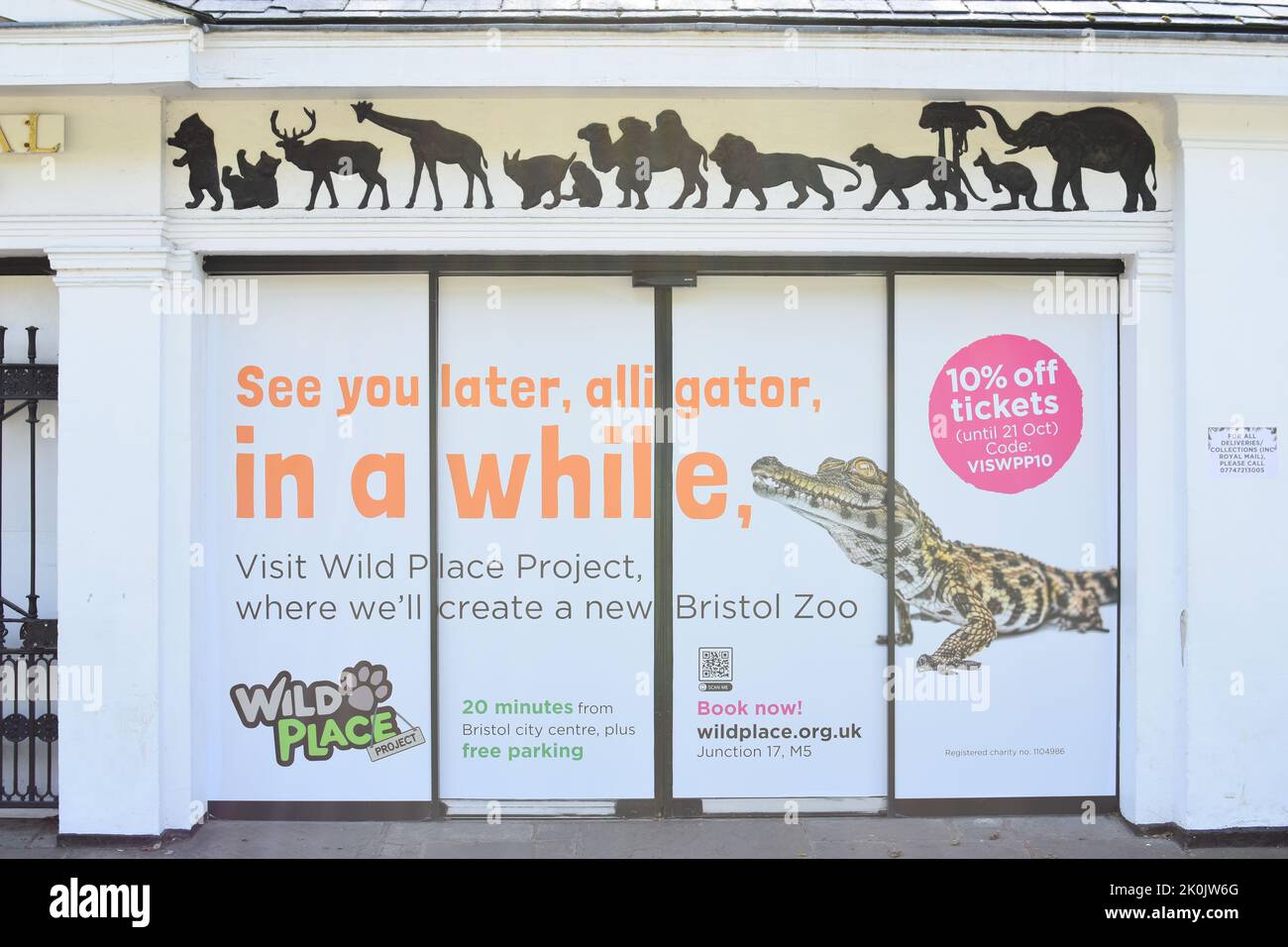 Writing on the building of Bristol Zoo saying 'See you later alligator, in a while, with a picture of a crocodile and other animals Stock Photo