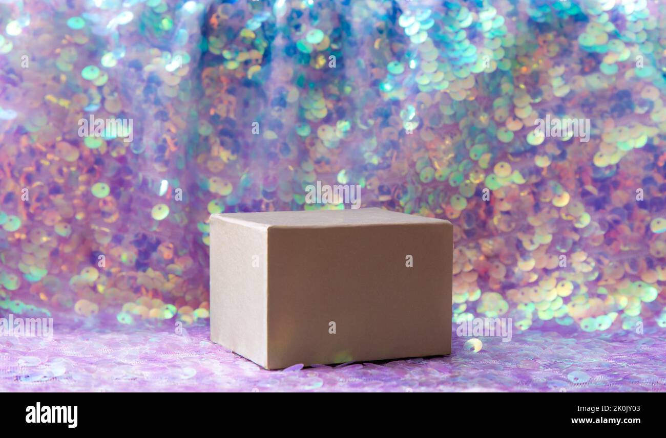 Beautiful iridescent purple color sequins textile background with square shape box pedestal for products. Lot of copy space. Side view. Stock Photo