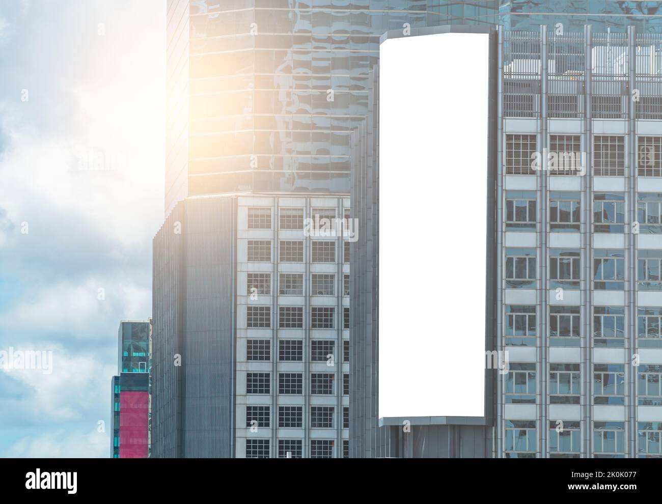 Big modern digital billboard on a high building, 3D empty a vertical digital billboard, blue sky background. Stock Photo