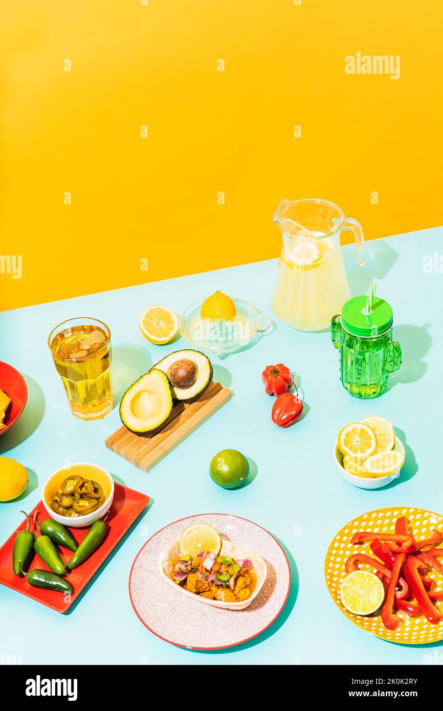 From above assorted traditional Mexican dishes and drinks placed on blue table near yellow wall Stock Photo