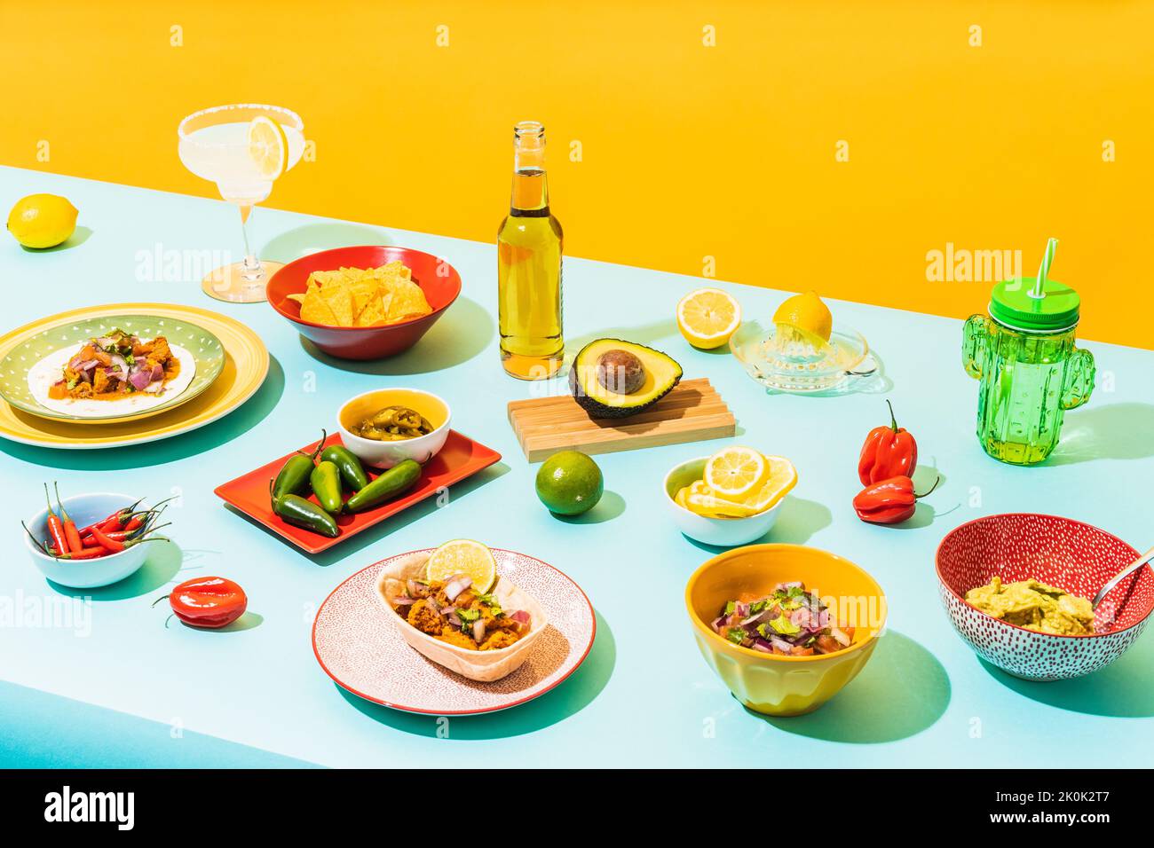 From above assorted traditional Mexican dishes and drinks placed on blue table near yellow wall Stock Photo