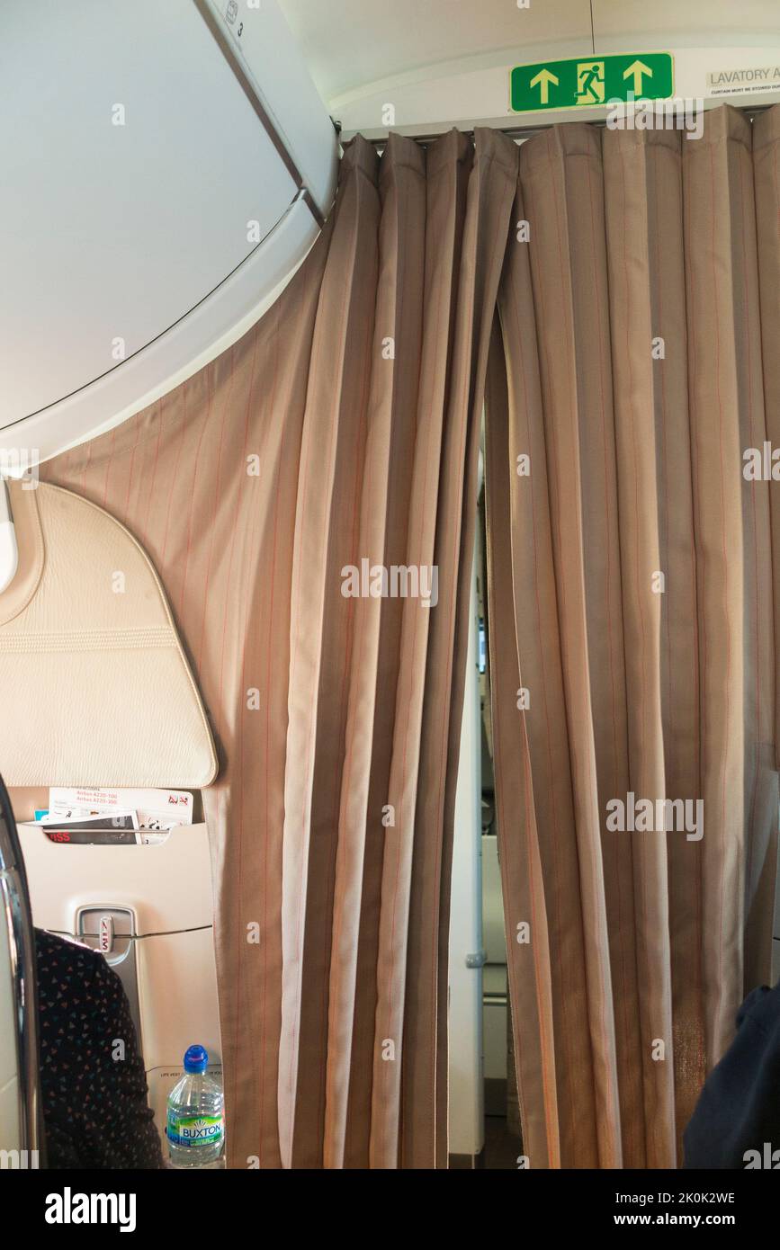 Curtains / curtain between Economy passengers and Business Class seats on an Airbus A220 passenger aircraft air craft plane airplane aeroplane. (131) Stock Photo