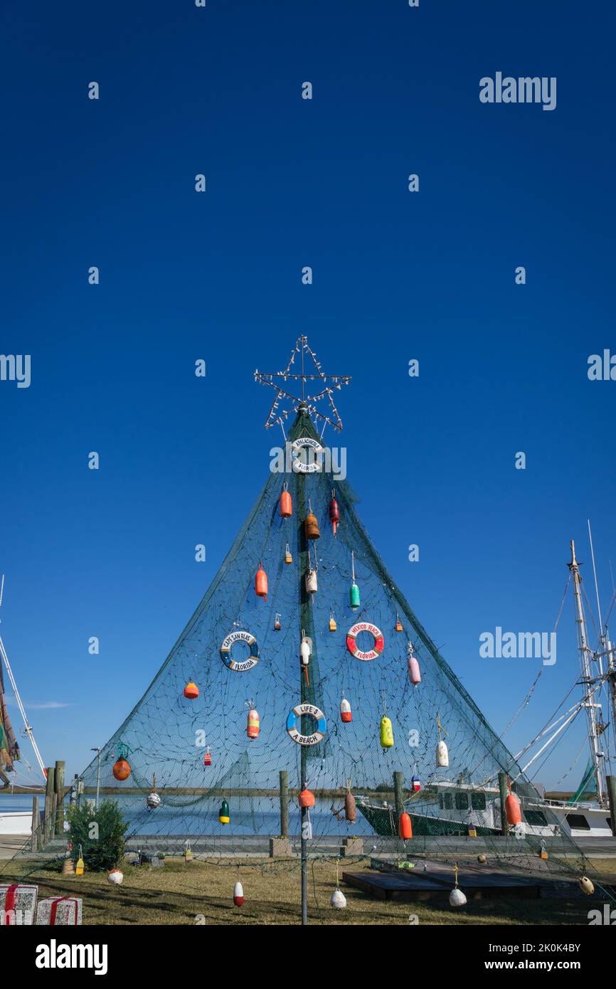 Christmas tree decorated with colorful fishing buoys in tropical setting in small Florida fishing town. Stock Photo
